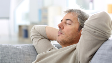 uomo sul divano intento a dormire dopo pranzo