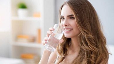 una ragazza beve un bicchiere d'acqua